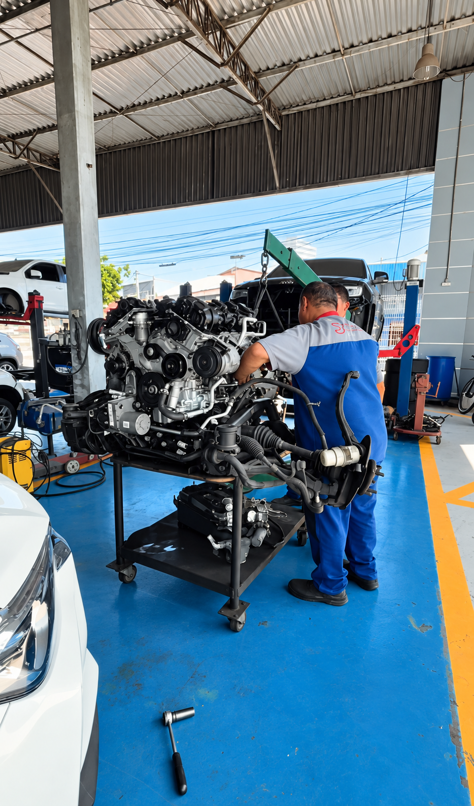 Mecânico da Econômica Auto Center trabalhando em um conjunto de motor